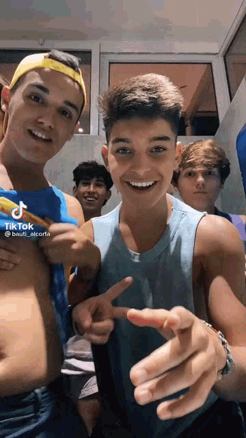 a group of young men are standing next to each other and smiling .