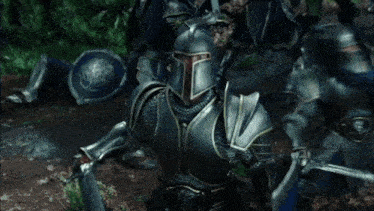 a group of knights in armor are standing next to each other in the woods .