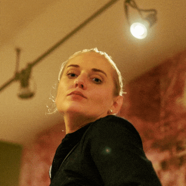 a woman in a black shirt looks at the camera
