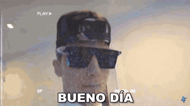 a man wearing sunglasses and a hat is saying bueno dia in spanish