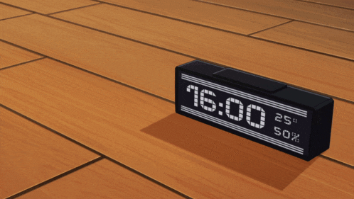 a digital clock on a wooden floor reads 16:00