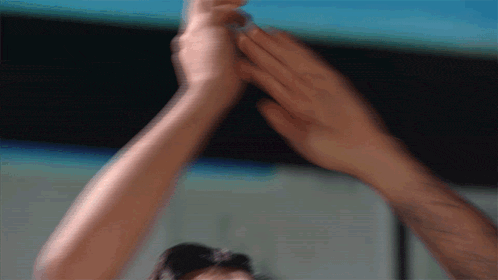 a man and a woman are giving each other high fives