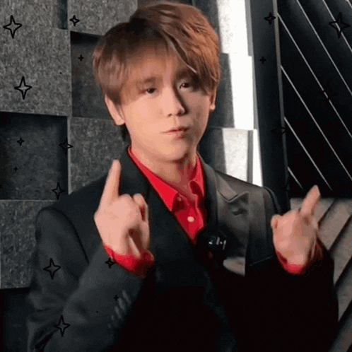a man in a suit and red shirt is giving the middle finger