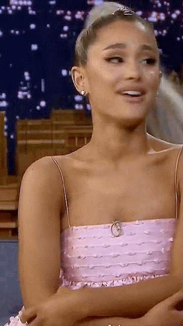 a woman in a pink dress is smiling and looking down