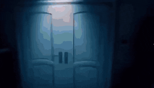 a dark room with a light coming through the door