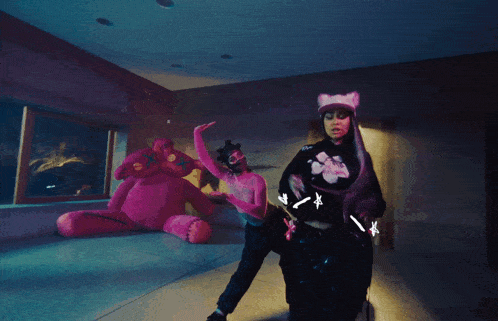 a woman wearing a cat ear hat and a black hoodie with a pink flower on it