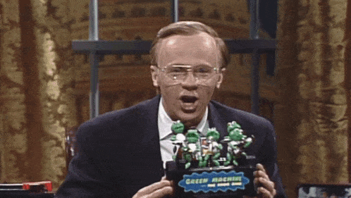 a man is holding a green machine toy