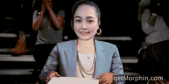 a pixelated image of a woman holding a piece of paper with the website getmorphin.com in the lower right corner
