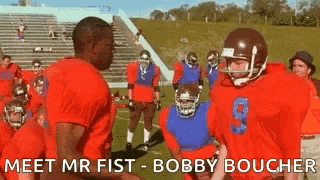 a group of football players are standing on a field and one of them is wearing a red jersey with the number 9 on it .