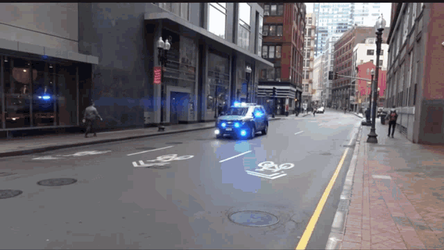 a police car is driving down a city street with a bike lane