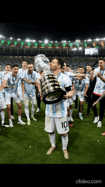 a soccer player with the number 10 on his shirt kisses the trophy