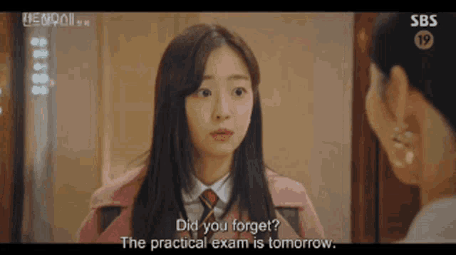 a girl in a pink coat and tie is talking to a woman in a white shirt .