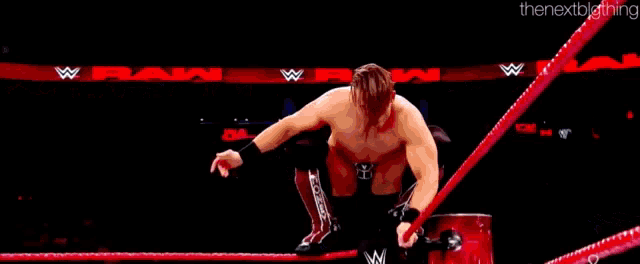 a wrestling match is being held in a ring with a referee and a crowd watching