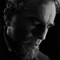 a black and white photo of a man with a beard .