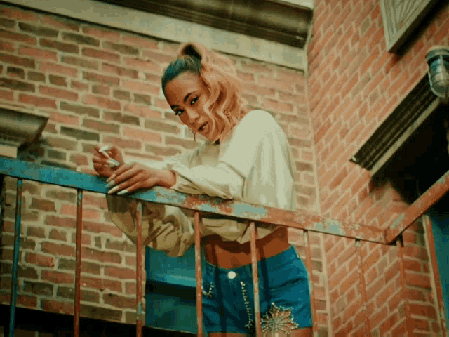 a woman standing on a balcony smoking a cigarette