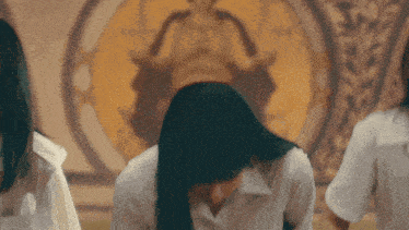 a woman with long black hair is sitting in front of a painting