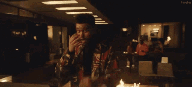 a man in a colorful jacket is talking on a cell phone .