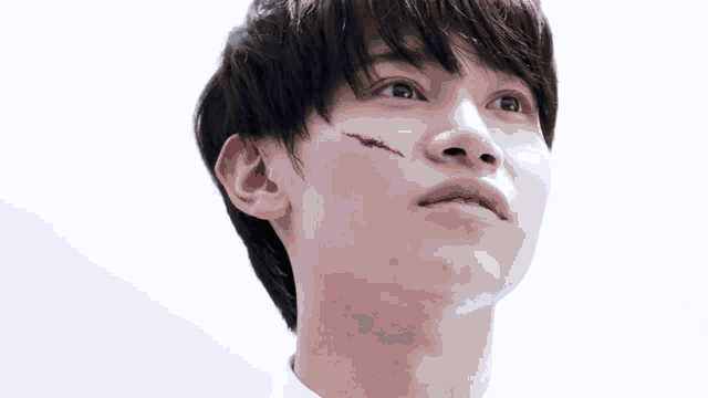 a close up of a man 's face with a scar on it
