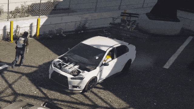 a white car is parked in a parking lot with its hood open