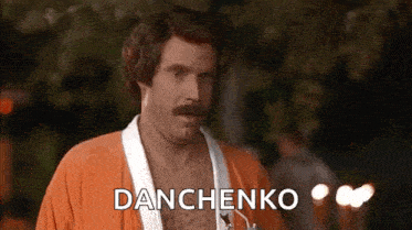 a shirtless man with a mustache is wearing an orange robe and a white robe .