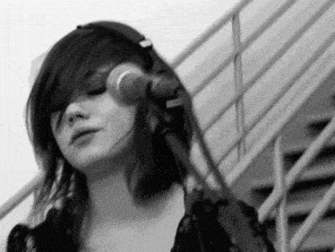 a woman wearing headphones is singing into a microphone