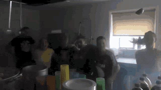 a group of people are gathered in a dark room and one of them is wearing a shirt that says ' a '