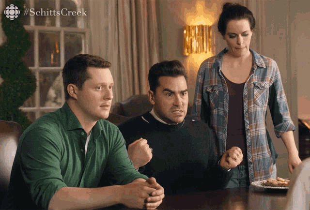 a group of people sitting at a table with the word schitts creek on the bottom
