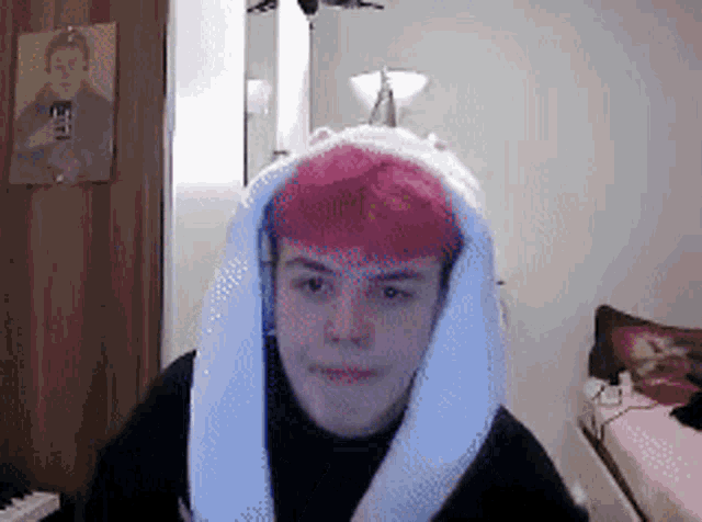 a man with pink hair is wearing a white scarf around his neck
