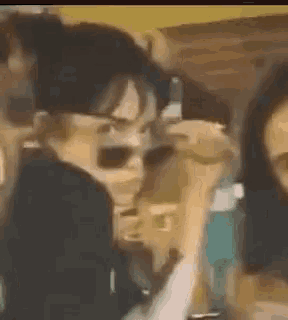 a man wearing sunglasses is talking on a cell phone .