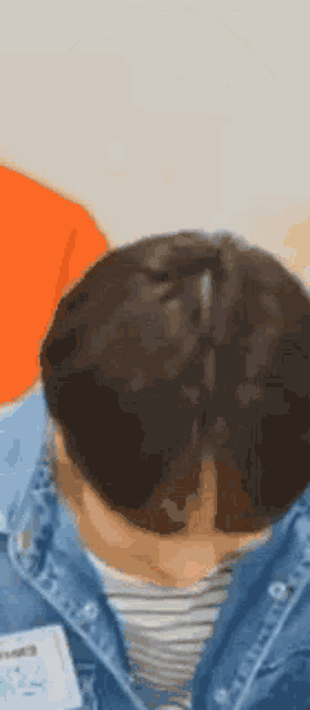 a close up of a person 's head with their eyes closed and a ponytail .