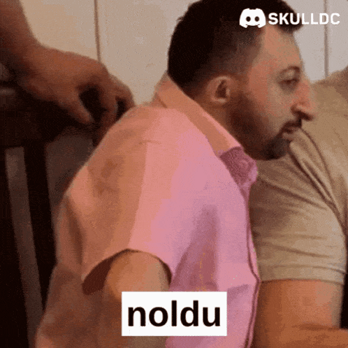 a man in a pink shirt has the word noldu written on his chest