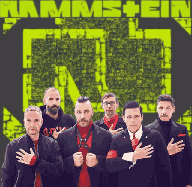 a group of men standing in front of a sign that says ' rammstein '
