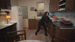 a woman is standing in a kitchen in front of a refrigerator