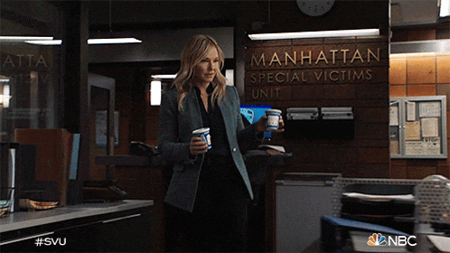 a woman is standing in front of a sign that says manhattan special victims unit
