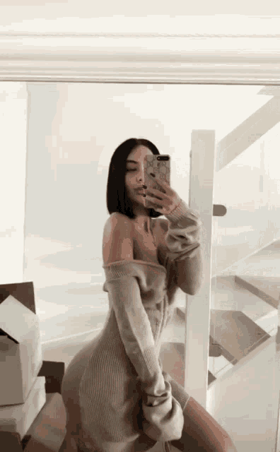 a woman taking a selfie in front of a mirror