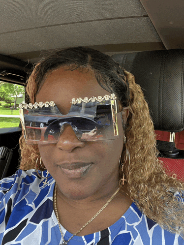 a woman in a car wearing sunglasses with rhinestones