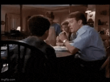 a group of people are sitting at a table in a living room .