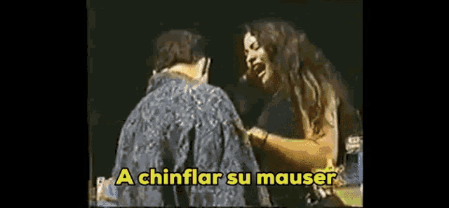 a man and a woman are standing next to each other on a stage with a caption that says a chinflar su mauser