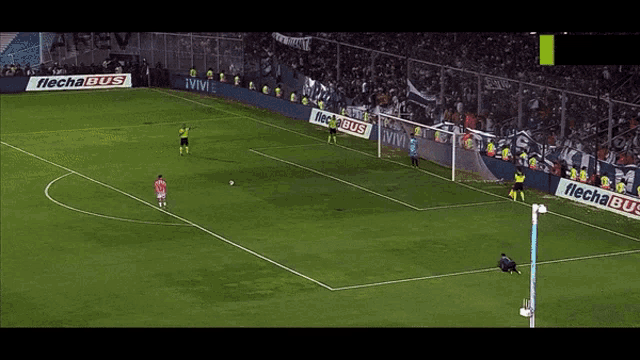 a soccer field with a flecha bus ad on the side
