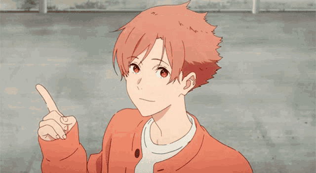 a young man with red hair is pointing up with his finger