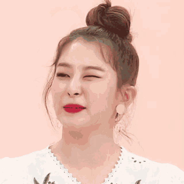 a woman with her eyes closed has a bun on her hair