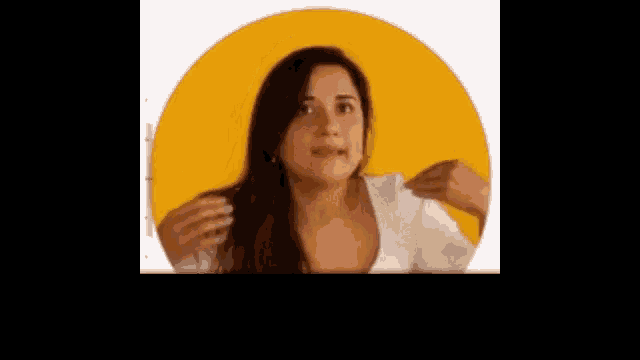 a woman is standing in front of a yellow circle and making a face .