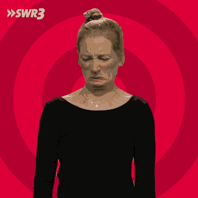 a woman making a funny face in front of a red background with swr3