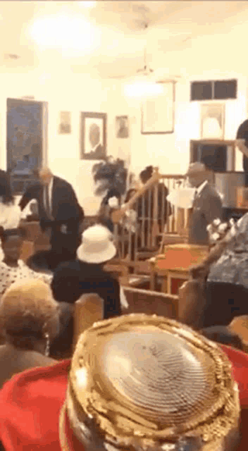 a group of people are gathered in a church with a gold object in the foreground
