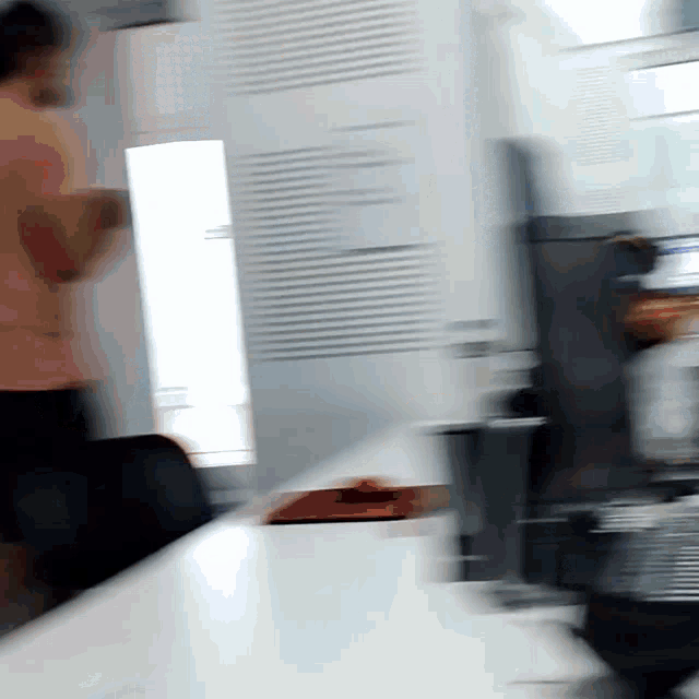 a blurry picture of a person standing in a room with a white wall