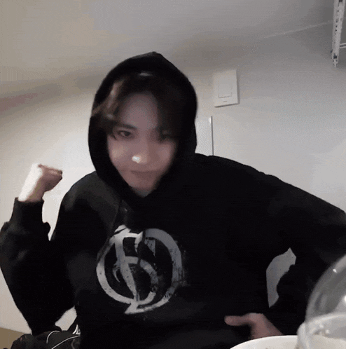 a person wearing a black hoodie with a white circle on the front
