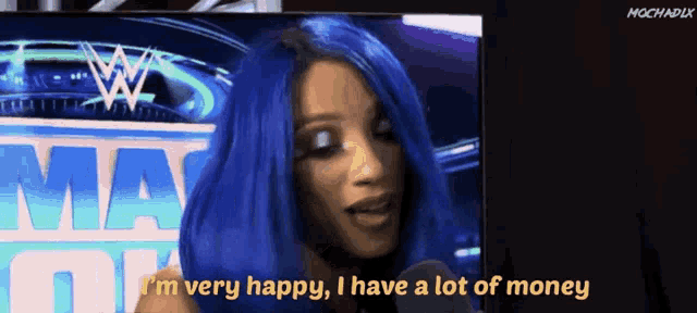 a woman with blue hair is talking into a microphone and says i 'm very happy i have a lot of money
