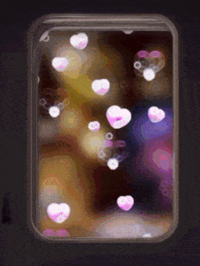 heart shaped bubbles are floating in a container with a dark background