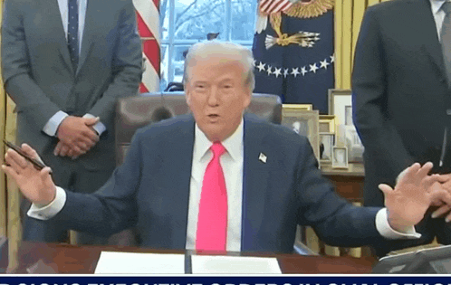 a man in a suit and tie is sitting at a desk