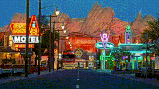 a motel sign is lit up at night in front of a mountain